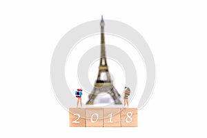 Happy New Year 2018. Miniature Group hiker and traveler backpack standing on wold map for travel Eiffel Tower in France and aroun