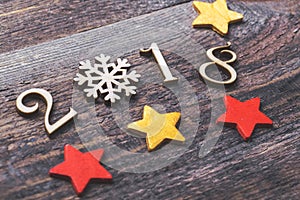 Happy New Year 2018 of real wooden figures with snowflake and stars on wooden background. Selective focus and toned image