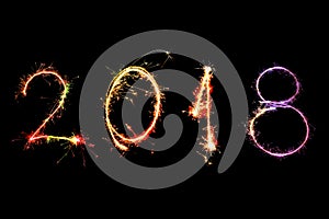Happy new year 2018 written with Sparkle firework on black background,