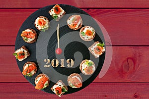 Happy New Year 2019! Clock showing 12 o`clock, creative food idea with smoked salmon canapes