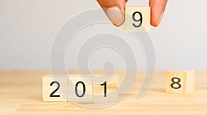 Happy new year 2019 trend concept, Hand man try to replace number of year from 2018 to 2019 on the wooden table