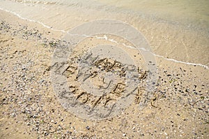 Happy new year 2019 written on tropical beach sand, copy space. Holiday concept