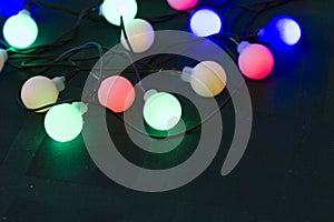 Happy New Year 2020. Christmas decorations on a dark green background with burning garland lights