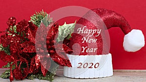 Happy new year 2020 message on a sparkling santa claus hat on a red background