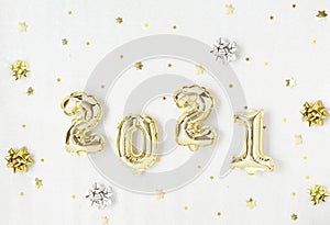 Happy New year 2021 celebration. Gold foil balloons numeral 2021 and gold star on silver background.