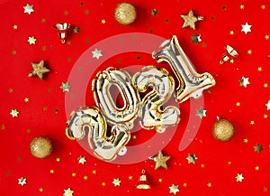 Happy New year 2021 celebration. Golden Christmas 2021 balloons and holiday decorations on red background.