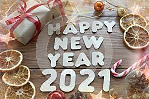 Happy new year 2021. Christmas composition. New year`s layout on a dark wooden background. Cones, toys, gift, garland