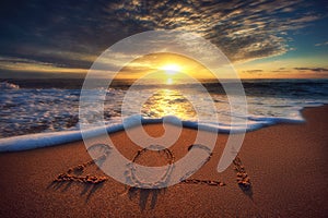 Happy New Year 2021 concept, lettering on the beach. Sea sunrise