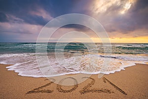 Happy New Year 2021 concept, lettering on the beach and Sea sunrise
