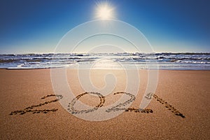 Happy New Year 2021 concept, lettering on the beach. Written text on the sea beach at sunrise