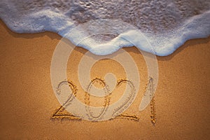 Happy New Year 2021 concept, lettering on the beach. Written text on the sea beach at sunrise