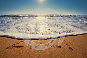 Happy New Year 2021 concept, lettering on the beach. Written text on the sea beach at sunrise