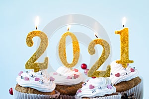 Happy New Year 2021 cupcakes with lighting candles. Merry Christmas and winter season greetings concept. Close up, copy space
