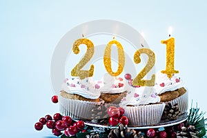 Happy New Year 2021 cupcakes with lighting candles. Merry Christmas and winter season greetings concept. Copy space