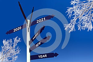 Happy new year 2021 on direction signs, snowy trees