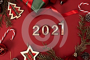 Happy New Year 2021. Golden digits 2021 with christmas hat are on red background with glitter. Holiday Party Decoration or
