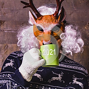 Happy New Year 2021! Man in a deer mask and winter clothes. Wildlife, climate, healthy lifestyle