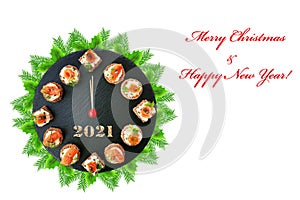 Happy New Year 2021! Smoked salmon canapes on black slate platter form a clock face showing midnight