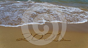 Happy new year 2021 written in the sand.Happy new year 2021 written in the sand by the sea