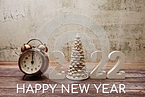 Happy New Year 2022 Calligraphy alphabet letter and Vintage alarm clock on wooden background