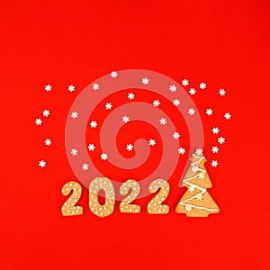 Happy New Year 2022. Christmas, winter holidays concept. Gingerbread cookies Number and snowflake set confetti on traditional red