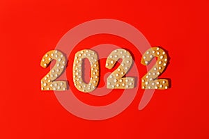 Happy New Year 2022. Christmas, winter holidays concept. Gingerbread cookies Number on traditional red background, fleyer,