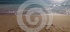 Happy New Year 2022, lettering on the beach with wave and clear blue sea.