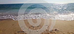 Happy New Year 2022, lettering on the beach with wave and clear blue sea.