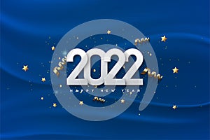 Happy new year 2022 with white numbers on a blue cloth background.