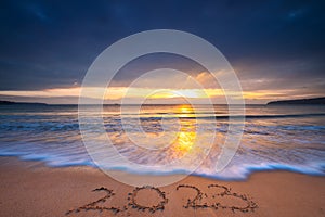 Happy New Year 2023 concept for travel, lifestyle, sport, meditation. 2023 text lettering on the ocean beach sand at sunrise. SeA