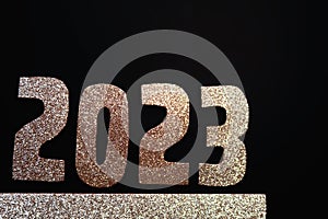 Happy New Year 2023. Golden numbers on a black background with glitter