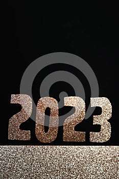 Happy New Year 2023. Golden numbers on a black background with glitter