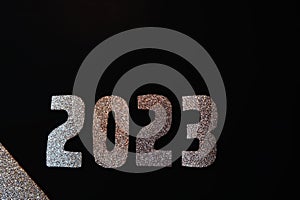 Happy New Year 2023. Golden numbers on a black background with glitter
