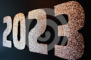 Happy New Year 2023. Golden numbers on a black background with glitter