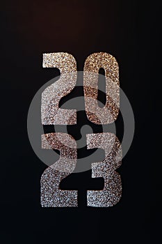 Happy New Year 2023. Golden numbers on a black background with glitter