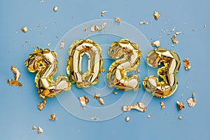 Happy New Year 2023 greeting card. 2023 golden foil balloons numbers and confetti. Top horizontal view copy space new year and