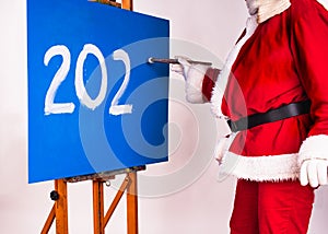 Happy New Year 2023- holiday greeting. Santa Claus in the image of an artist writes the numbers 202