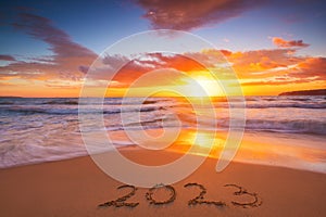 Happy New Year 2023 travel and lifestyle concept, text lettering on the beach shore. Ocean sunrise. Sea sunset.