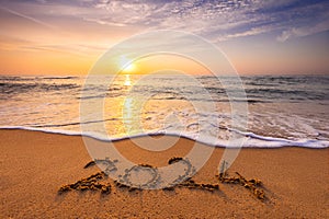 Happy New Year 2024 concept, lettering on the beach. Written text on the sea beach at sunrise