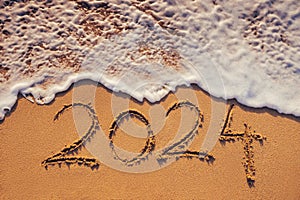 Happy New Year 2024 concept, lettering on the beach. Written text on the sea beach at sunrise