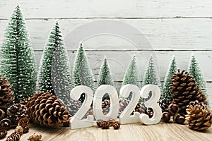 Happy New year calendar 2023 concept decoration with Christmas tree and pine cones on white wooden background