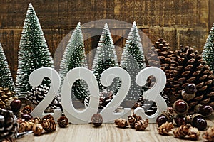 Happy New year calendar 2023 concept decoration with Christmas tree and pine cones on wooden background