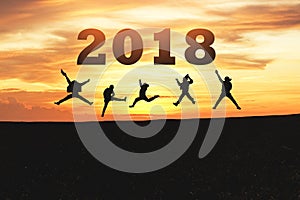 Happy new year card 2018. Silhouette of teenager jumping on mountain hill with fantastic sunset sky background