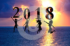 Happy new year card 2018. Silhouette young woman jumping on tropical beach over the sea and 2018 number with sunset background