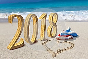 Happy new year card. Two New Year`s caps of Santa Claus on beach and on sand heart is drawn and inscription 2018