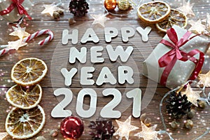 Happy new year 2021. Christmas composition. New year`s layout on a dark wooden background. Cones, toys, gift, garland