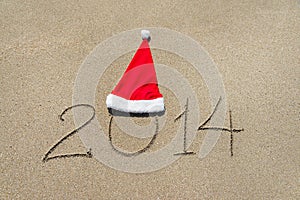 Happy new year 2014 with christmas hat on sandy beach - holiday