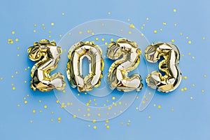 Happy New year and christmas holiday concept 2023. Gold balloons with glitter stars on blue background. Gift card with space for
