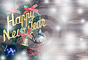 Happy new year and Christmas ornaments hang on Christmas Tree have space wood background