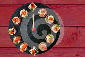 Happy New Year! Clock showing 12 o`clock, creative food idea with smoked salmon canapes